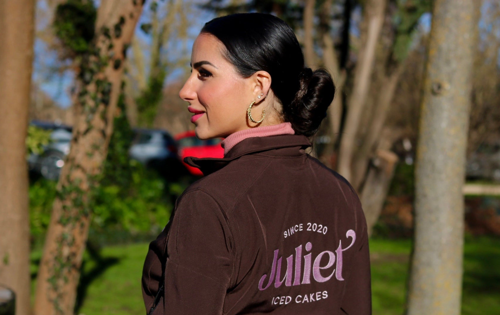 Juliette de dos qui regarde sur la gauche, sourire, et veste de chez Juliet Iced Cakes
